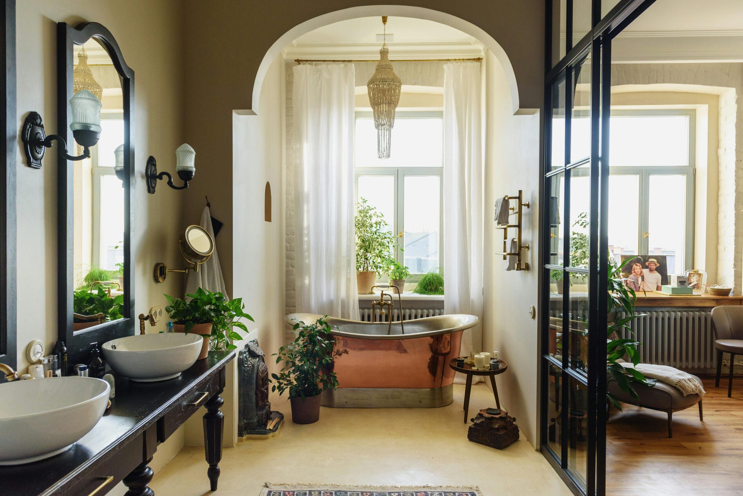 A stylish modern bathroom featuring a clawfoot bathtub and lush greenery.