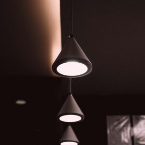 Elegant cone-shaped pendant lights creating a modern atmosphere in a dark interior space.